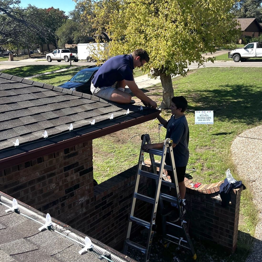 RiverHills Christmas Lights crew installing C9 bulbs along a roofline