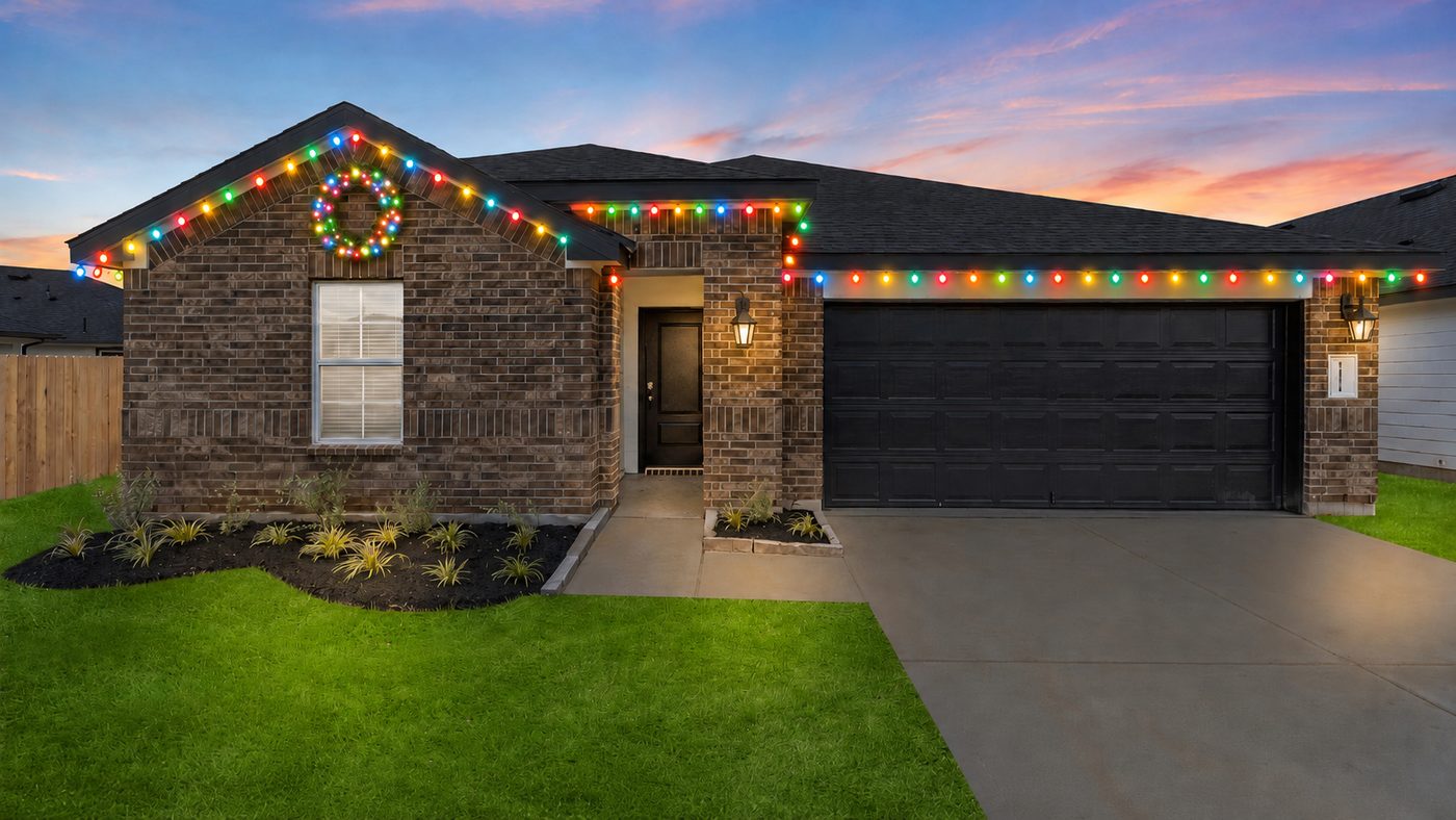 Home with multicolor roofline Christmas lights and a lit wreath on the gable